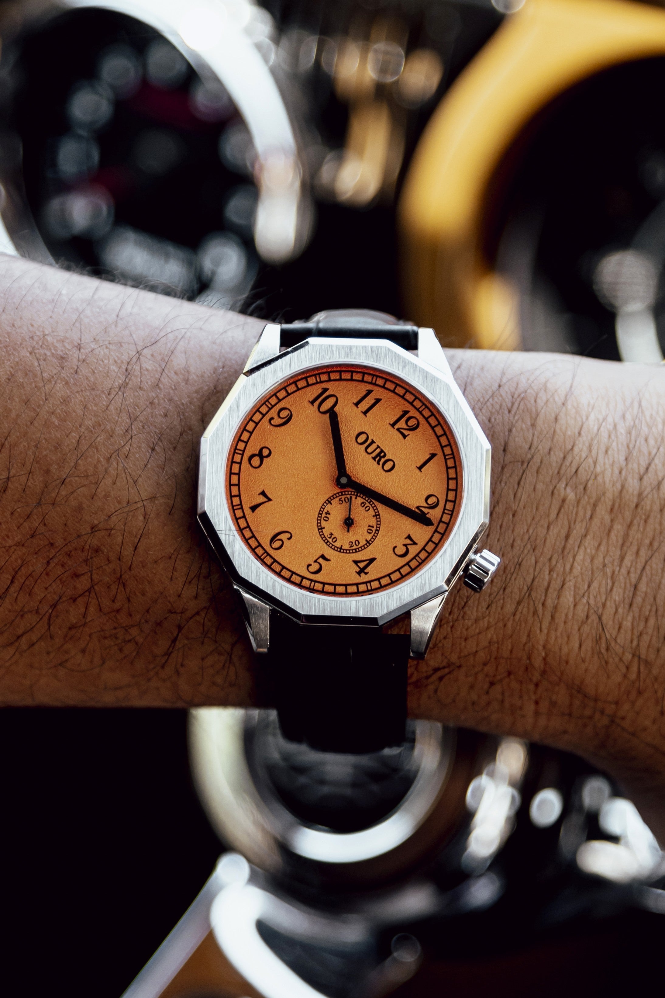 Gros plan sur la Driver’s watch RW-003 à cadran orange grainé portée au poignet.